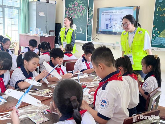 Các tình nguyện viên LS Hàn Quốc hướng dẫn học sinh làm máy bay đồ chơi. Ảnh: ĐVCC