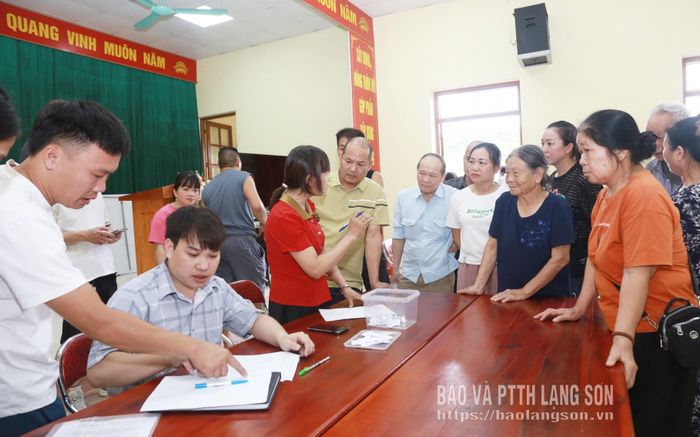 Cán bộ phòng chuyên môn của UBND phường Đông Kinh hướng dẫn người dân thực hiện thủ tục bốc thăm nhận đất tái định cư