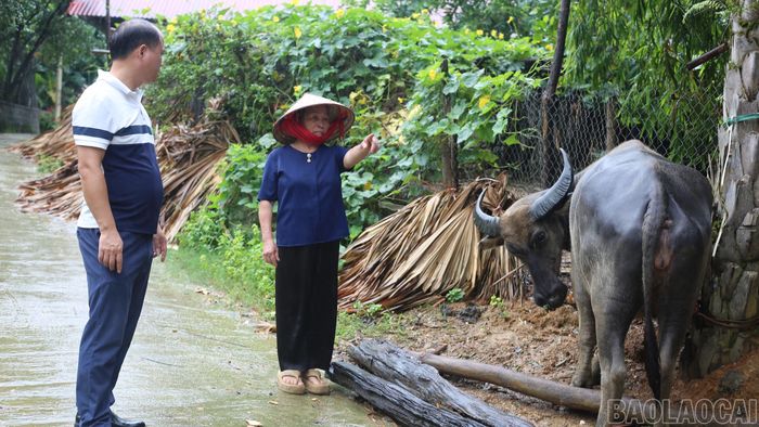 Bà Nguyễn Thị Tư trao đổi với cán bộ xã Bảo Ái về đời sống và việc phát triển kinh tế gia đình.