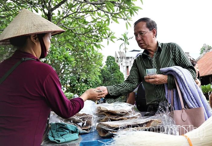 Du khách mua sản phẩm mì gạo, bánh đa Hùng Lô về làm quà.