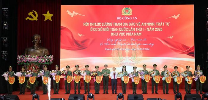 Thiếu tướng Nguyễn Viết Giang và đồng chí Trần Văn Bảy tặng hoa và cờ lưu niệm chúc mừng các đội thi. (Ảnh: Cổng TTĐT Bộ Công an)