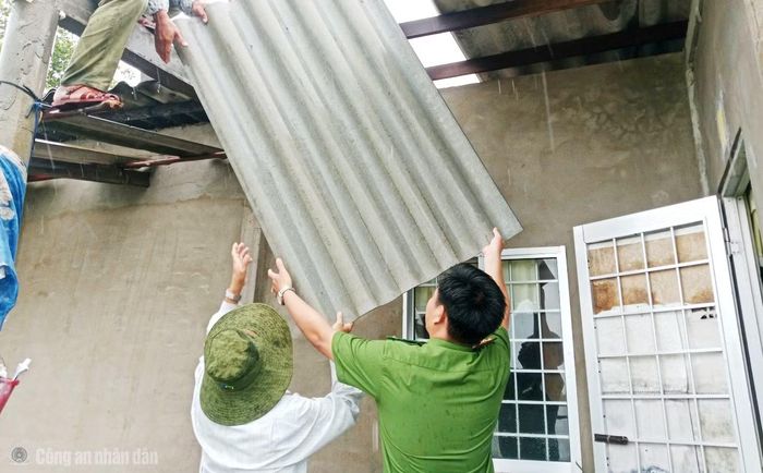 Công an xã Đầm Dơi cùng người dân sửa lại nhà do dông lốc gây thiệt hại.