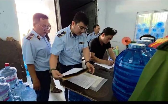 Đoàn kiểm tra tiến hành kiểm tra đột xuất một cơ sở kinh doanh nước uống đóng bình.