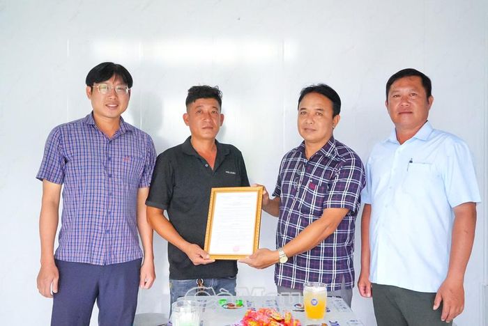 Đồng chí Võ Minh Trí, Ủy viên Ban Thường vụ Đảng ủy, Chủ tịch Ủy ban MTTQ Việt Nam Xã Hồ Thị Kỷ, trao Quyết định bàn giao nhà cho gia đình ông Lê Văn Tâm, ấp Bào Nhàn.