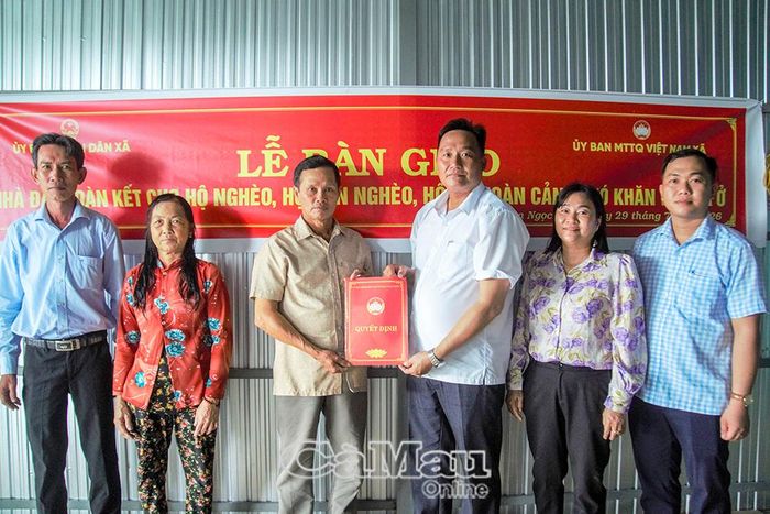Đồng chí Tạ Văn Toàn, Phó Chủ tịch Ủy ban MTTQ xã, Chủ tịch Hội Nông dân xã, trao Quyết định bàn giao nhà cho gia đình ông Lê Văn Thống, ấp Tân Ân.