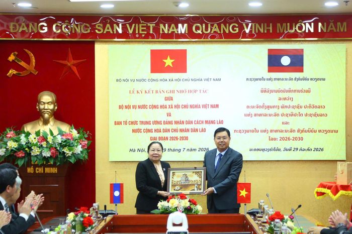 Quyền Bộ trưởng Bộ Nội vụ Nguyễn Tiến Hải và đại diện phía Lào trao đổi quà tặng nhân dịp ký kết Bản ghi nhớ hợp tác.