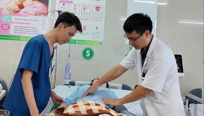 Bác sĩ chuyên khoa I Phạm Mạnh Toàn và bác sĩ Phùng Nam, Bệnh viện Sản Nhi Ninh Bình đang thăm khám cho sản phụ sau phẫu thuật.