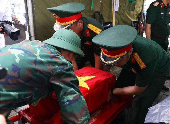 Trang trọng thực hiện quy trình khai quật, đưa hài cốt liệt sĩ chưa xác định danh tính về khu vực lấy mẫu sinh phẩm sĩ tại Nghĩa trang liệt sĩ Ngọc Hồi (xã Thanh Trì). Ảnh: Văn Điệp – TTXVN
