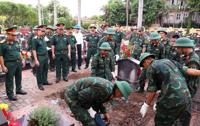 Thực hiện quy trình khai quật, đưa hài cốt liệt sĩ chưa xác định danh tính tại Nghĩa trang liệt sĩ Ngọc Hồi (xã Thanh Trì). Ảnh: Văn Điệp – TTXVN