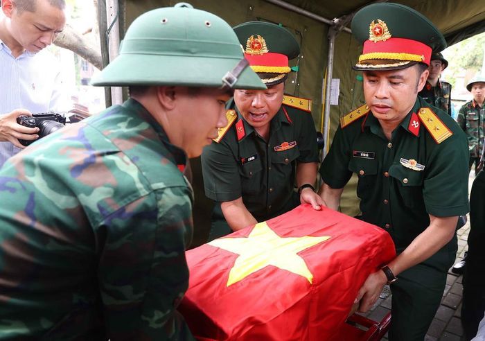 Thực hiện nghi thức phủ Quốc kỳ trang trọng, tri ân Anh hùng liệt sĩ đã hy sinh vì độc lập, tự do của Tổ quốc. Ảnh: Văn Điệp – TTXVN