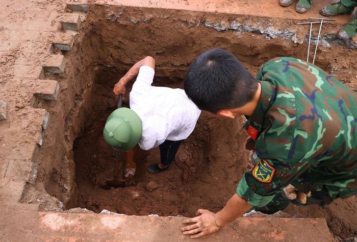 Lực lượng khai quật tiến hành phá dỡ nhiều lớp đất đá để tiếp cận được hài cốt liệt sĩ tại Nghĩa trang liệt sĩ Ngọc Hồi (xã Thanh Trì). Ảnh: Văn Điệp – TTXVN