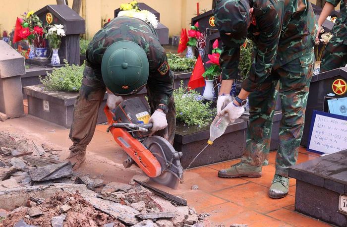 Lực lượng khai quật tiến hành phá dỡ nhiều lớp đất đá để tiếp cận được hài cốt liệt sĩ tại Nghĩa trang liệt sĩ Ngọc Hồi (xã Thanh Trì). Ảnh: Văn Điệp – TTXVN