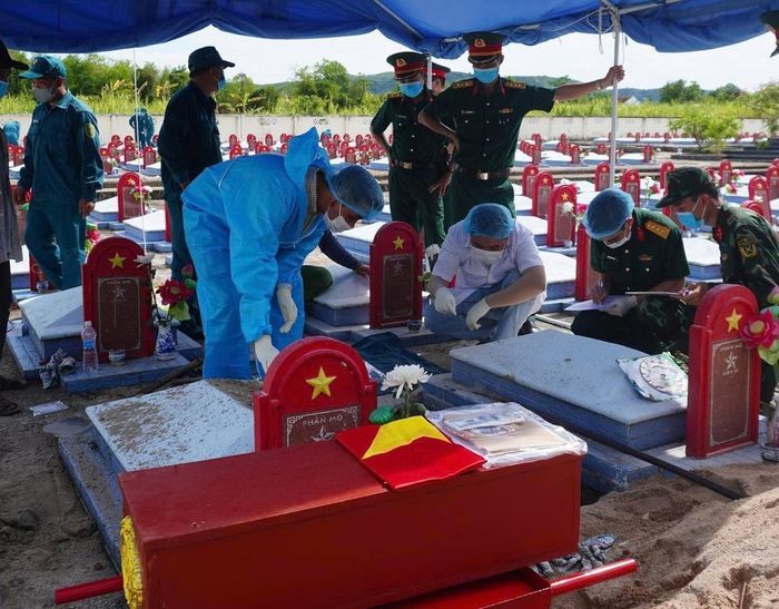 Cán bộ, chiến sĩ Bộ Chỉ huy Quân sự tỉnh Đắk Lắk lấy mẫu sinh phẩm của các liệt sĩ chưa xác định thông tin tại Nghĩa trang liệt sĩ Xuân Quang 2 (xã Đồng Xuân). Ảnh: Tường Quân - TTXVN