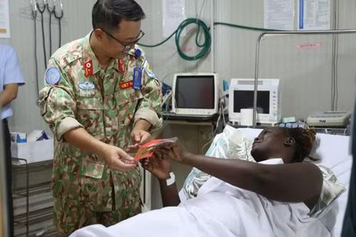 Trung tá, Tiến sĩ, Bác sĩ Trần Đức Tài, Giám đốc Bệnh viện dã chiến cấp 2 số 7 thăm hỏi bệnh nhân điều trị tại Bệnh viện. (Ảnh: TIẾN PHÚC)