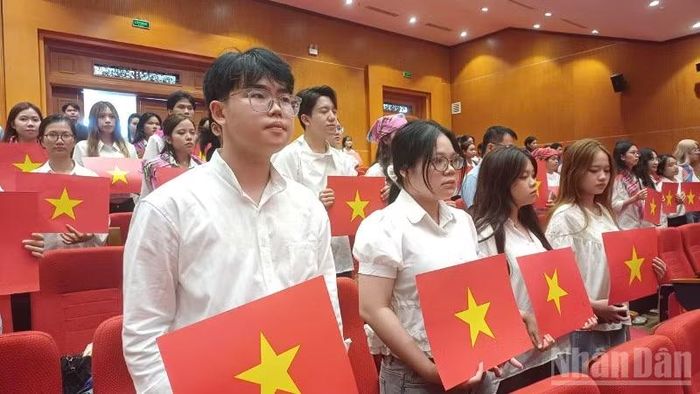 Đại biểu và sinh viên dự hội thảo thực hiện nghi lễ chào cờ.