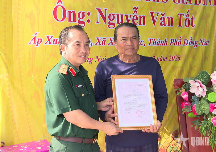 Trung tướng Nguyễn Xuân Sơn, Bí thư Đảng ủy, Chính ủy Trường Sĩ quan Lục quân 2 trao quyết định tặng nhà cho ông Nguyễn Văn Tốt.