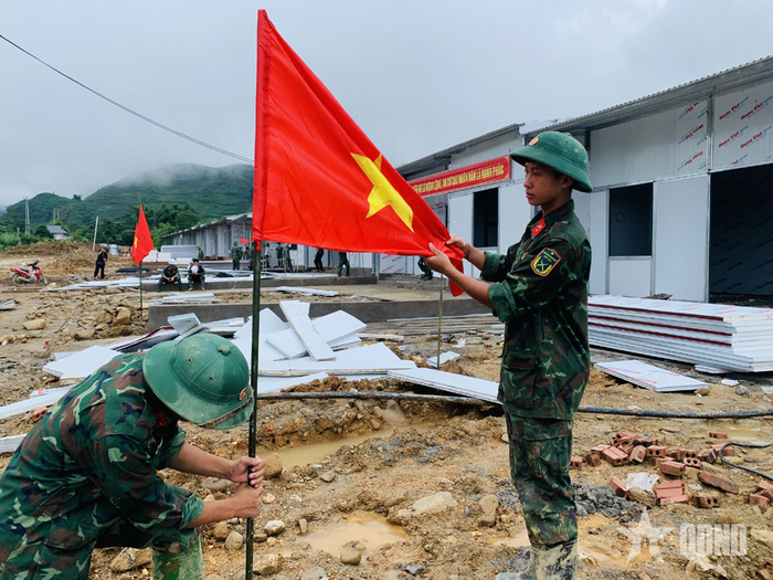 Chiến sĩ Trung đoàn 880 (Bộ CHQS tỉnh Lai Châu) trang trí, treo cờ Tổ quốc tặng người dân.