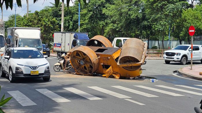 Chiếc xe lu rơi khỏi xe tải trên đường Trần Văn Giàu. Ảnh: HỮU TÂM