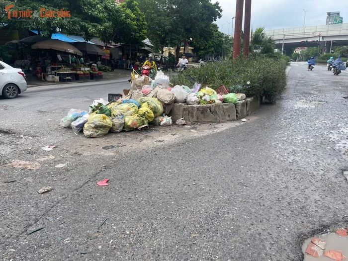 Một khu vực tập kết rác nằm ngay trên mặt đường khiến lòng đường bị thu hẹp. Rác thải tồn đọng không chỉ gây mất mỹ quan mà còn ảnh hưởng đến việc lưu thông của các phương tiện qua khu vực.