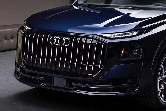 Phần đầu xe SUV Audi Q9 mới nổi bật với lưới tản nhiệt cỡ lớn sử dụng các nan dọc cùng thiết kế dựng đứng, kết hợp dải viền màu đen kéo dài sang hai bên tạo diện mạo khỏe khoắn. Phía sau, vị trí gắn biển số được chuyển xuống cản sau, giúp cửa khoang hành lý có thiết kế liền mạch hơn.