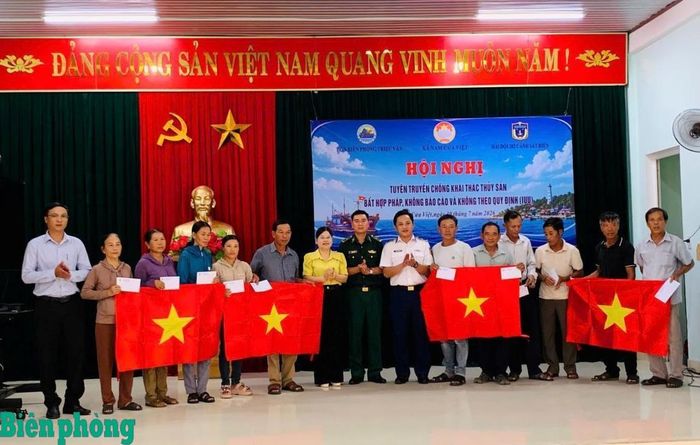 Ban tổ chức trao tặng cờ Tổ quốc, tặng quà cho bà con ngư dân. Ảnh: Xuân Thế