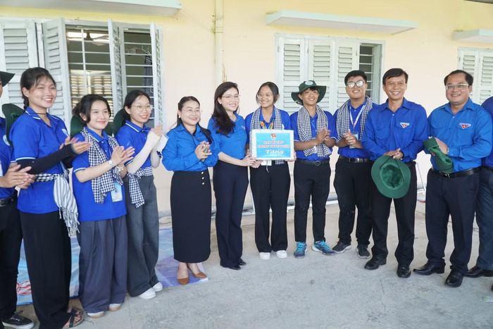 Chị Hồ Hồng Nguyên tặng quà và động viên các bạn sinh viên tình nguyện.