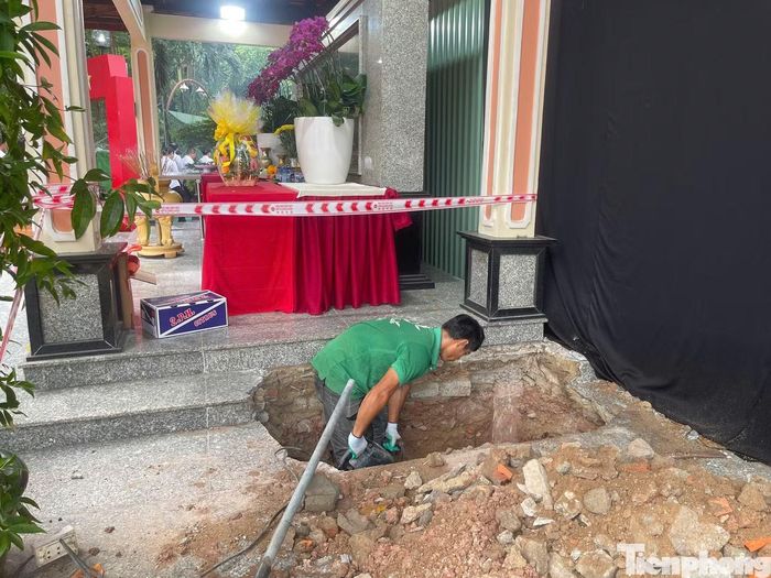 Lực lượng chức năng chuẩn bị các điều kiện để di dời nhà bia tưởng niệm, mở rộng khu vực tìm kiếm hài cốt liệt sĩ tại công viên Lê Thị Riêng. Ảnh: Nguyễn Tiến