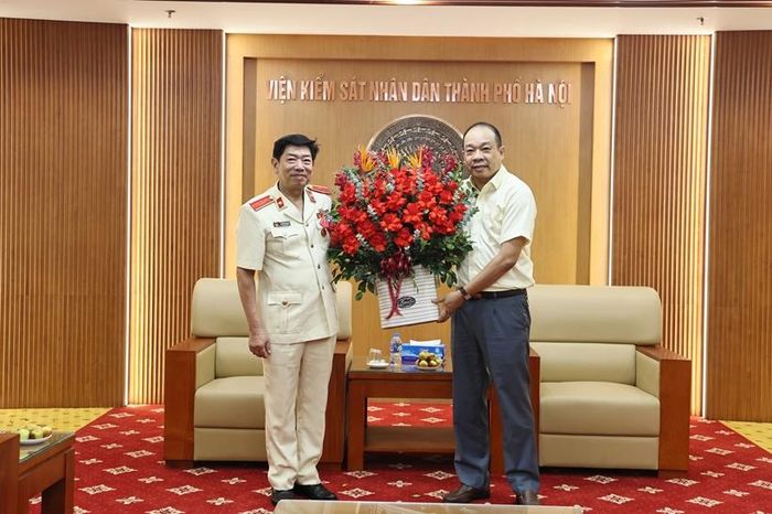 Đồng chí Trần Quốc Thái, Phó Trưởng Thi hành án dân sự TP Hà Nội tặng hoa chúc mừng đồng chí Nguyễn Văn Dũng.