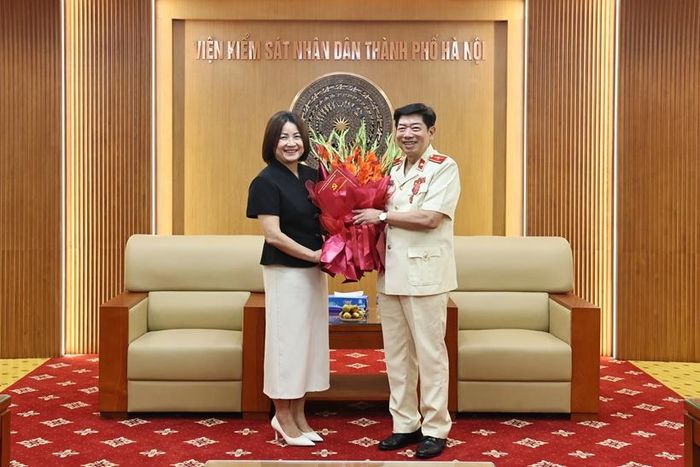 Đồng chí Phạm Thị Nguyên Hạnh, Phó Bí thư Đảng ủy khối các cơ quan TP Hà Nội tặng hoa chúc mừng đồng chí Nguyễn Văn Dũng