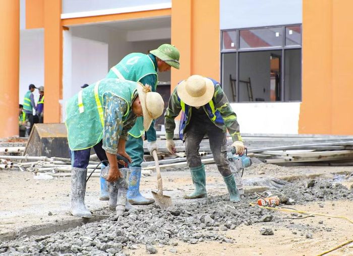 Công nhân thi công nền sân, hoàn thiện khuôn viên Trường Phổ thông nội trú liên cấp Tiểu học và Trung học cơ sở xã Thanh Nưa. (Ảnh: Xuân Tư/TTXVN)