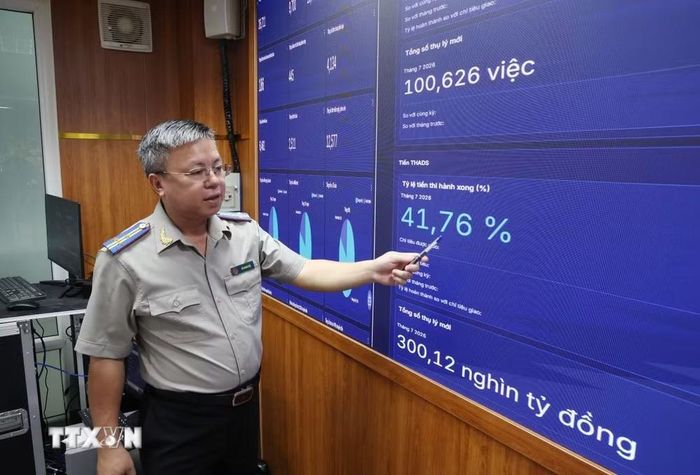 Ông Đỗ Phong Hóa, Phó Trưởng Thi hành án dân sự TP Hồ Chí Minh, theo dõi dữ liệu trên Trung tâm Giám sát và Điều hành thông minh (IOC THADS). (Ảnh: Hồng Đạt/TTXVN)