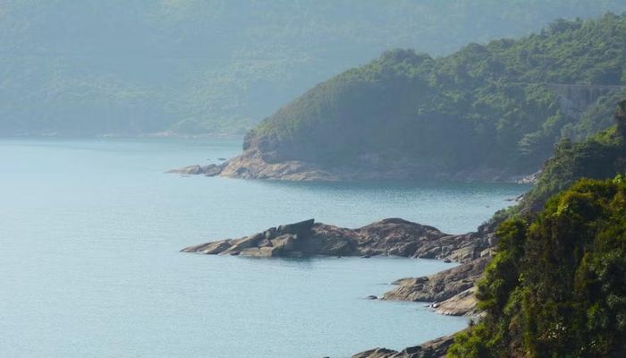 Những hòn đá xám sẫm nằm rải rác dưới chân núi Hải Vân, như những mảnh ghép thô ráp của thiên nhiên xen lẫn giữa vẻ đẹp dịu dàng của biển xanh Lăng Cô. (Ảnh: Văn Dũng/TTXVN)