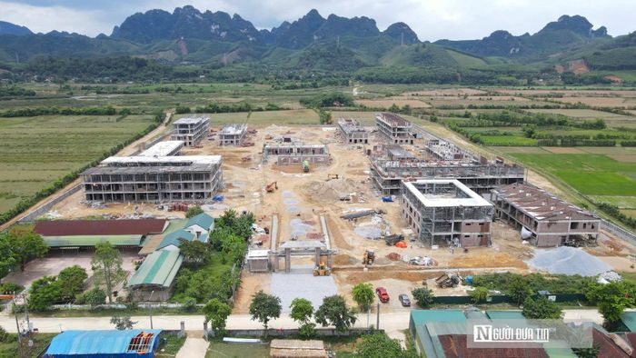 Tại điểm Trường liên cấp xã biên giới Môn Sơn, không khí thi công đang diễn ra khẩn trương để kịp tiến độ. Những người công nhân xây dựng đang căng mình làm việc liên tục không ngừng nghỉ. Trao đổi với Người Đưa Tin, ông Thái Doãn Tài, cán bộ tư vấn giám sát thuộc Công ty CP Xây dựng và Thương mại Gia Thịnh cho biết, dự án điểm Trường liên cấp biên giới Môn Sơn rộng 5 ha này gồm 12 hạng mục lớn cùng hệ thống phụ trợ. Hiện tại, trường đã cất nóc được 10/12 khối nhà và dự kiến hoàn thành cất nóc toàn bộ trong tháng 7. Các đơn vị đang tập trung nhân lực để lắp mái tôn cho 10 tòa nhà trước ngày 5/8 và đẩy nhanh khâu hoàn thiện hạ tầng.