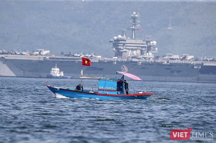 Một tàu cá Việt Nam đi ngang qua vùng neo đậu của siêu tàu sân bay USS George Washington. Ảnh XM.