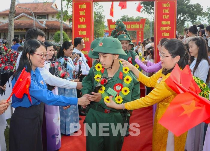 Các đoàn thể và người thân động viên thanh niên trước giờ lên đường nhập ngũ, góp phần tạo khí thế phấn khởi trong ngày hội giao quân tại Tây Ninh. Ảnh: Minh Phú - TTXVN