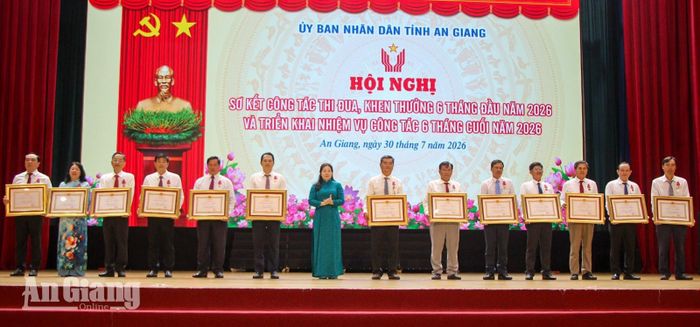 Đồng chí Lê Hồng Thắm trao Huân chương Lao động hạng ba cho các cá nhân.
