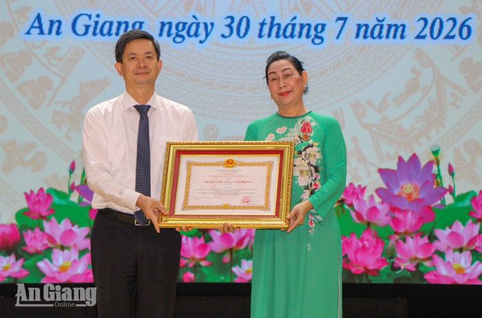 Đồng chí Lê Quang Tùng trao Huân chương Lao động hạng nhất cho bà Lê Thị Vệ.
