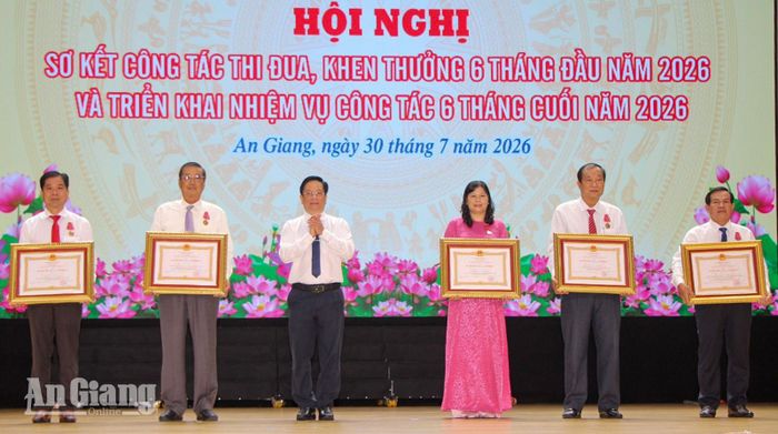 Đồng chí Hồ Văn Mừng trao Huân chương Lao động hạng nhì cho các cá nhân.