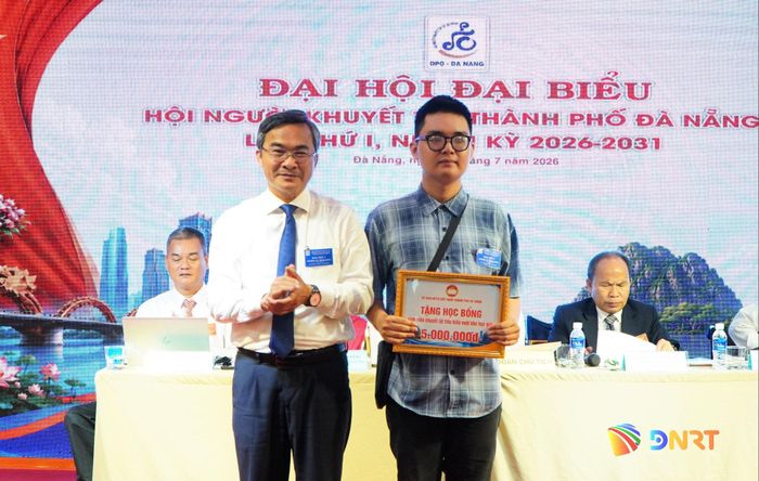 Phó Chủ tịch Ủy ban MTTQ Việt Nam thành phố Nguyễn Phi Hùng trao học bổng cho sinh viên Lê Nam Khang tại đại hội. Ảnh: TÂM ĐAN