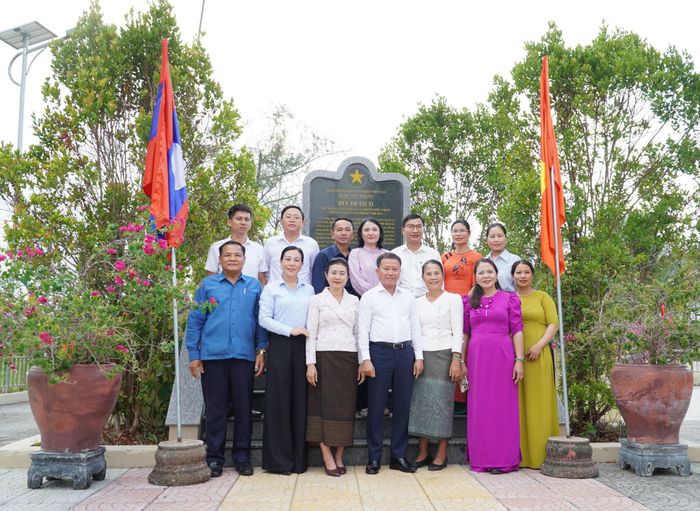 Đoàn cán bộ Ủy ban Mặt trận Lào xây dựng đất nước các tỉnh Nam Lào cùng các đại biểu chụp hình lưu niệm tại Bia di tích Khu kháng chiến Hạ Lào và Phòng Biên chính miền Nam Trung Bộ thời kỳ 1948 - 1954. Ảnh: N.ĐOAN