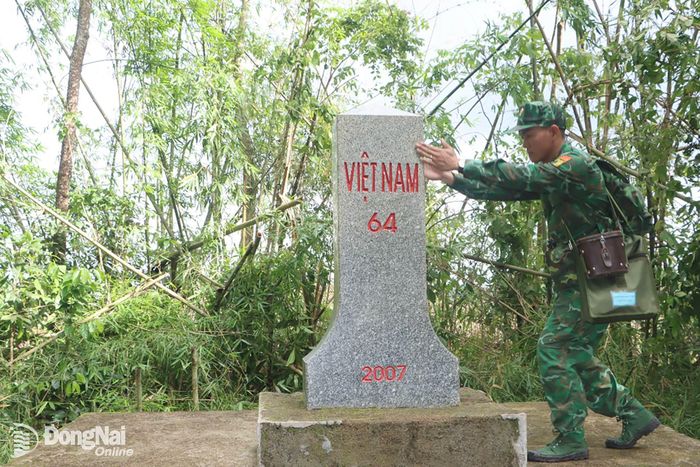 Sau nghi thức chào cột mốc, từng cán bộ, chiến sĩ cẩn trọng kiểm tra hiện trạng cột mốc, quan sát từng chi tiết, đối chiếu số hiệu, tình trạng bề mặt, vị trí và khu vực xung quanh. Những thao tác tưởng chừng đơn giản ấy lại mang ý nghĩa hết sức quan trọng, bởi mỗi cột mốc là biểu tượng pháp lý. Trong ảnh: Cán bộ Đồn biên phòng Phước Thiện kiểm tra hiện trạng cột mốc đôi 64. Ảnh: Vũ Thuyên