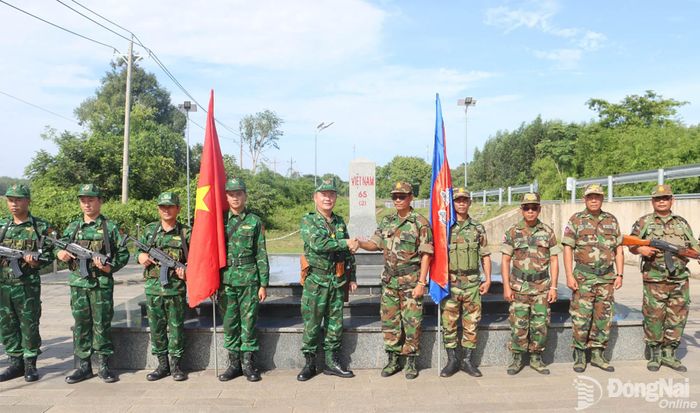 Sau chặng đường dài tuần tra song phương, khi đến cột mốc biên giới, cán bộ, chiến sĩ lực lượng hai bên dành cho nhau cái bắt tay thân tình và lời chào trang trọng. Đó không chỉ là một nghi thức giao tiếp thông thường, mà còn là biểu tượng của sự tôn trọng, tin cậy và tinh thần hợp tác giữa những người cùng mang trên vai trách nhiệm bảo vệ đường biên, giữ gìn cuộc sống bình yên cho nhân dân hai bên biên giới. Trong ảnh: Cán bộ, chiến sĩ Đồn biên phòng cửa khẩu Hoàng Diệu và lực lượng biên phòng Campuchia thực hiện nghi thức chào cột mốc và bắt tay chào nhau. Ảnh: Vũ Thuyên