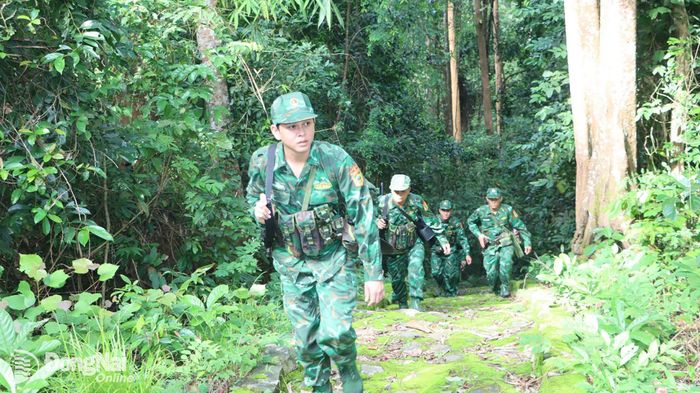 Dẫu ba lô nặng trĩu trên vai, mồ hôi thấm ướt lưng áo, nhưng ánh mắt của các chiến sĩ Đồn biên phòng Phước Thiện vẫn luôn hướng về phía trước, sắc sảo và đầy cảnh giác. Mỗi bước chân đều chắc chắn, mỗi ánh nhìn đều quan sát kỹ từng dấu vết, từng cột mốc, từng khoảng rừng dọc tuyến biên giới. Trong ảnh: Cán bộ, chiến sĩ Đồn biên phòng Phước Thiện trên đường tuần tra. Ảnh: Vũ Thuyên