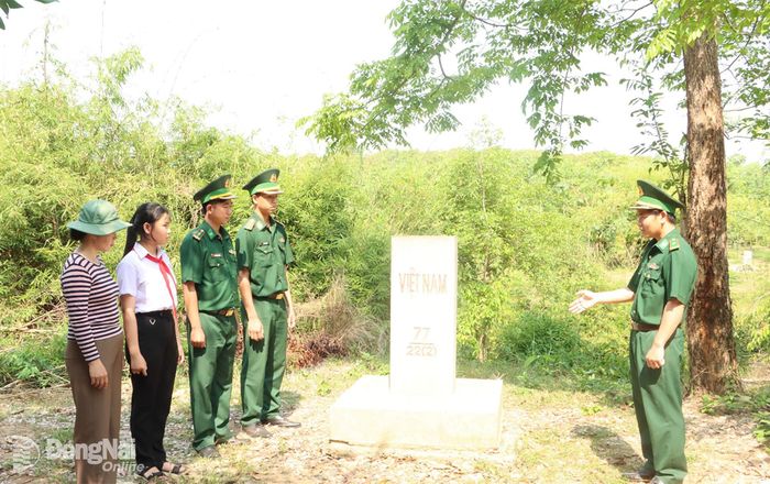 Cùng với tuần tra, cán bộ, chiến sĩ bộ đội biên phòng còn tận tình giới thiệu với người dân, học sinh về ý nghĩa của hệ thống đường biên, cột mốc. Từ đó mỗi người dân sẽ trở thành những "cột mốc sống", tích cực phối hợp với lực lượng chức năng trong quản lý, bảo vệ biên giới. Trong ảnh: Cán bộ, chiến sĩ Đồn biên phòng cửa khẩu Lộc Thịnh giới thiệu cho học sinh, phụ huynh khu vực biên giới về ý nghĩa thiêng liêng của cột mốc biên giới quốc gia. Ảnh: Vũ Thuyên