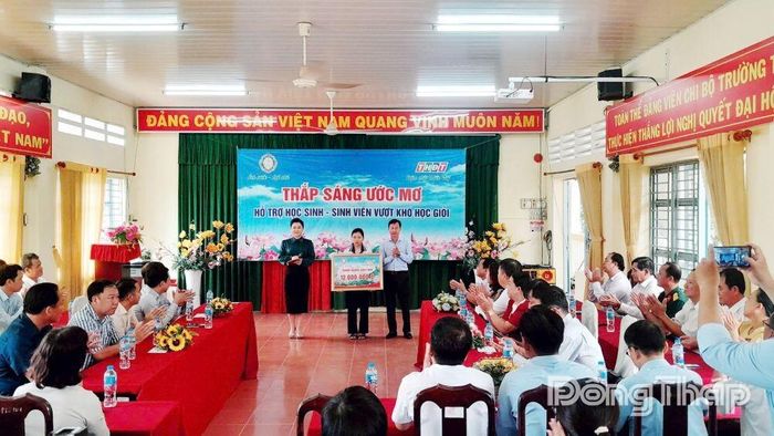 Đại diện Công ty TNHH MTV Xổ số kiến thiết Đồng Tháp trao bảng biểu trưng học bổng "Thắp sáng ước mơ" trị giá 12 triệu đồng cho em Nguyễn Ngọc Bảo Trân.