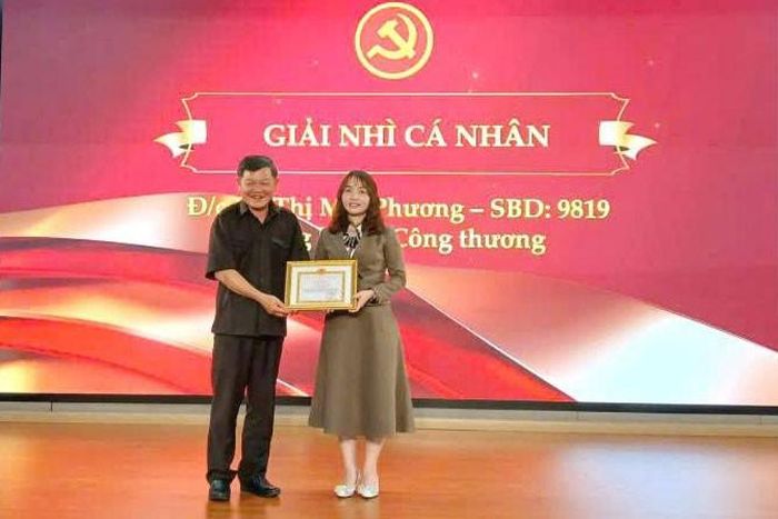 Đồng chí Nguyễn Hữu Khánh, Phó Trưởng Ban Tuyên giáo và Dân vận Tỉnh ủy trao giải Nhì cá nhân cho thí sinh Võ Thị Mai Phương, thuộc Đảng bộ Sở Công Thương