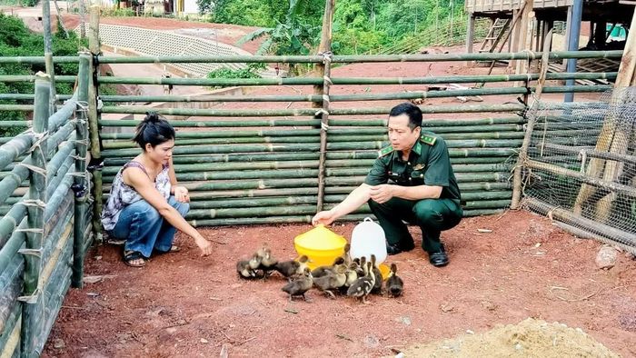 Cán bộ Đồn Biên phòng Cồn Roàng hướng dẫn kỹ thuật chăn nuôi ngan cho hộ nghèo - Ảnh: T.M