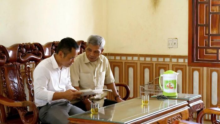 Thầy giáo Hồ Quang Tuyến (áo trắng) gặp gỡ các già làng, trưởng bản để hoàn thiện tài liệu chữ viết Bru-Vân Kiều- Ảnh: A.T