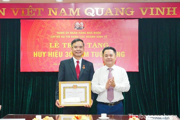 Đồng chí Nguyễn Ngọc Cảnh - Ủy viên Ban Thường vụ Đảng ủy, Phó Thống đốc NHNN trao huy hiệu cho đồng chí Nguyễn Xuân Bắc