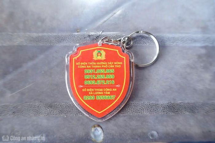 Công an xã Lương Tâm tặng móc khóa ANTT có số điện thoại Công an cho người dân.